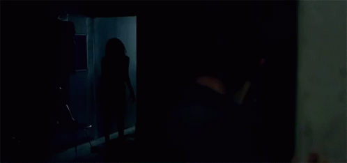 a person is standing in a room with clothes hanging on the racks