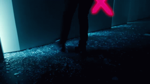 A Person Is Standing In Front Of A Broken Glass Door GIF