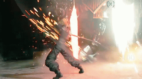 A Person Is Standing In Front Of A Fire With A Sword . GIF