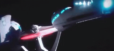 A Person Is Standing In Front Of A Projector Screen With Blue Lights . GIF