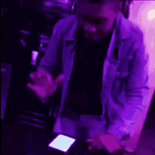 a person is standing in front of a purple light .