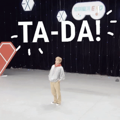 A Person Is Standing In Front Of A Sign That Says Ta-Da GIF