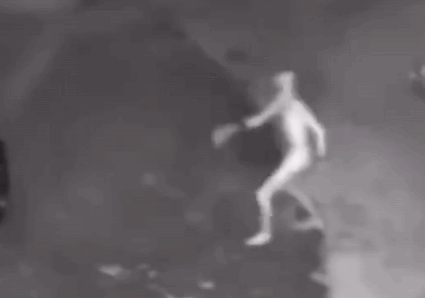 A Person Is Standing In The Dark With Their Arms Outstretched In A Black And White Photo . GIF