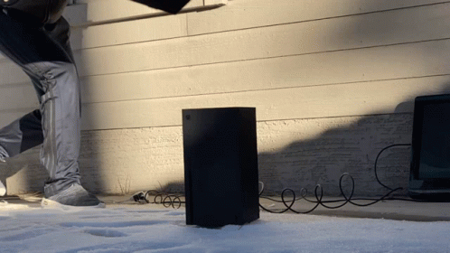 A Person Is Standing Next To A Black Box That Is Plugged Into A Wall GIF