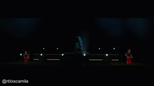 A Person Is Standing On A Stage With A Globe In The Background GIF