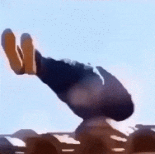 A Person Is Standing On Top Of A Sand Dune In The Desert With A Blue Sky In The Background . GIF