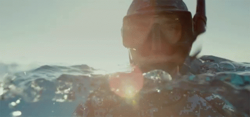 A Person Is Swimming In The Ocean Wearing A Mask And Goggles GIF