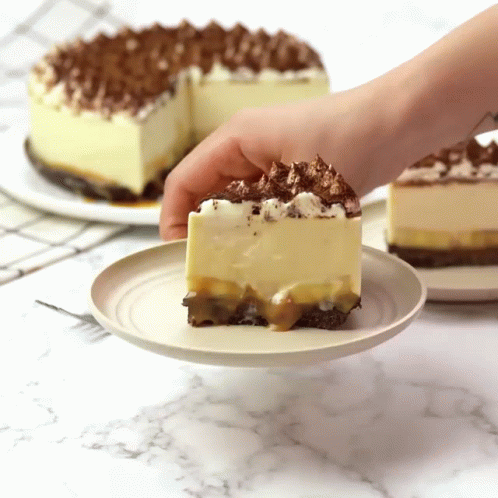 A Person Is Taking A Slice Of Cake From A Plate GIF