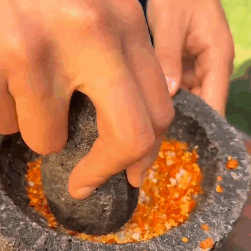 A Person Is Using A Mortar And Pestle To Crush A Vegetable GIF