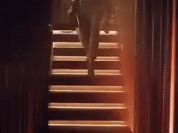A Person Is Walking Up A Set Of Stairs . GIF