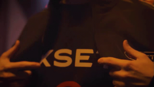 A Person Is Wearing A Black Shirt With The Word Xset On It GIF
