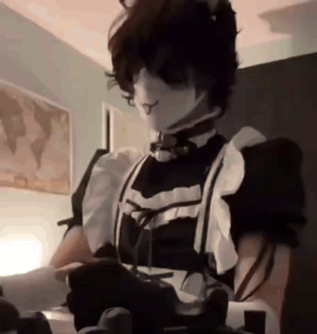 a person is wearing a maid costume and holding a video game controller .