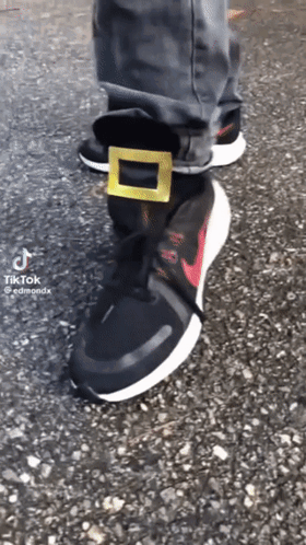A Person Is Wearing A Pair Of Black Nike Shoes GIF