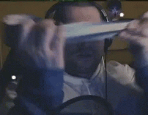 A Person Is Wearing A Virtual Reality Headset And Headphones While Sitting In Front Of A Computer Screen . GIF