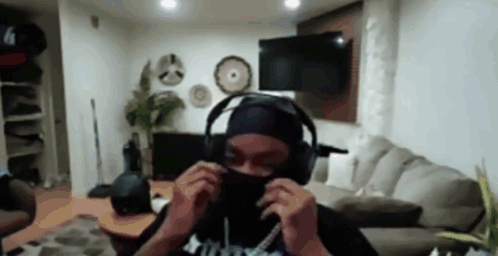 A Person Is Wearing Headphones And A Mask In A Living Room . GIF