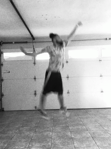 A Person Jumping In The Air In A Garage GIF
