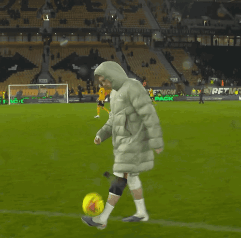 A Person Kicking A Soccer Ball On A Field That Has A Sign That Says " Our Loving Evolution " GIF