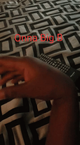 A Person Laying On A Bed With A Blanket That Says Onna Big B On It GIF