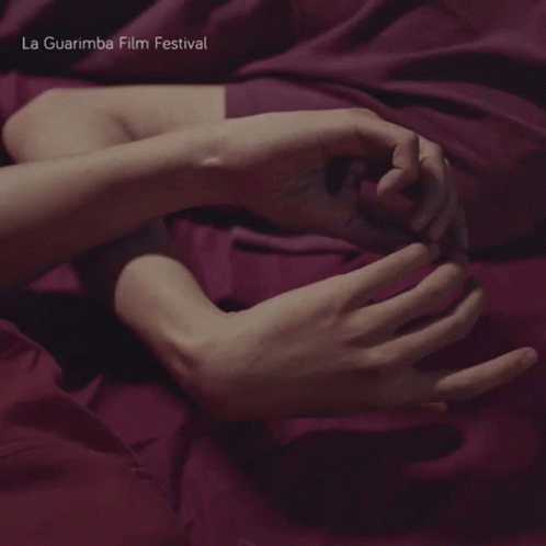 A Person Laying On A Bed With The Words La Guarimba Film Festival Written On The Bottom GIF