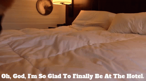 A Person Laying On A Bed With The Words Oh God I 'M So Glad To Finally Be At The Hotel Below Them GIF