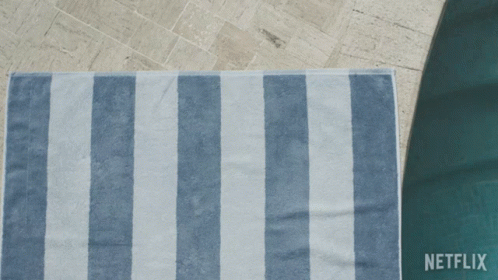 A Person Laying On A Blue And White Striped Towel With Netflix Written On The Bottom GIF