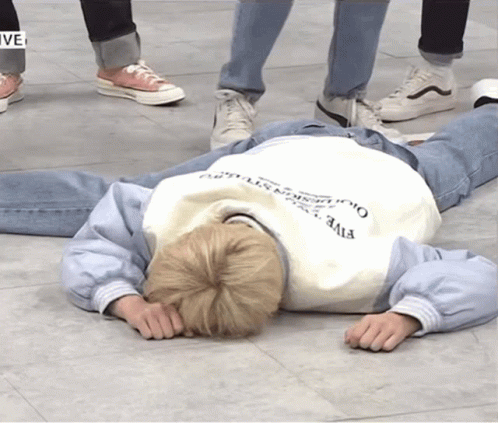 A Person Laying On The Floor Wearing A Sweatshirt That Says Five On It GIF
