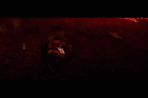 A Person Laying On The Ground In A Dark Room GIF