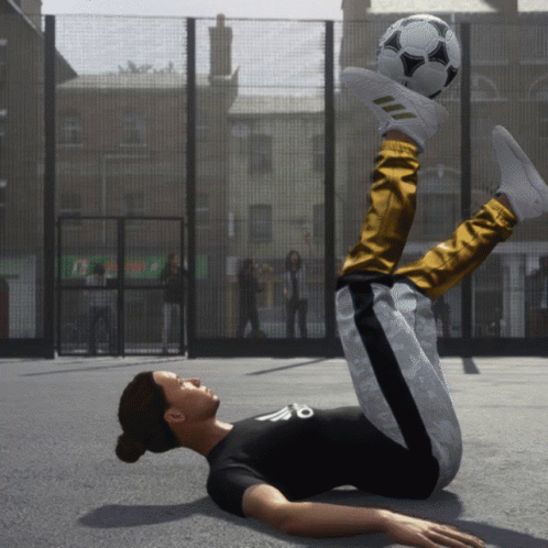 A Person Laying On The Ground With A Soccer Ball On Their Foot GIF