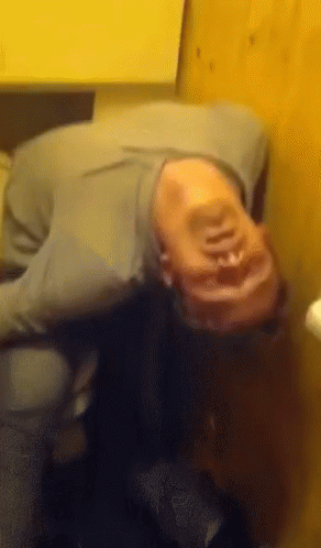 A Person Laying On Their Back With Their Head On A Table GIF