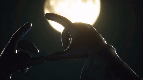 A Person Making A Heart With Their Hands In Front Of A Full Moon GIF
