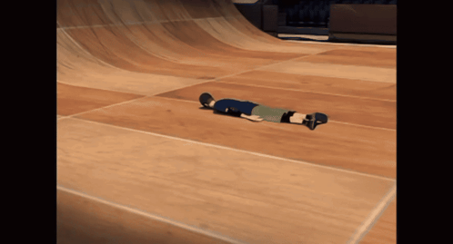 A Person On A Skateboard Laying On The Floor GIF