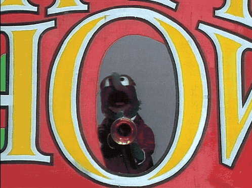 a person playing a trumpet in front of a sign that says " hot "