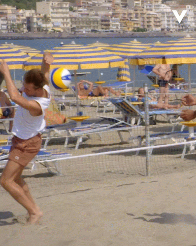 A Person Playing Volleyball On A Beach With A V On The Bottom GIF