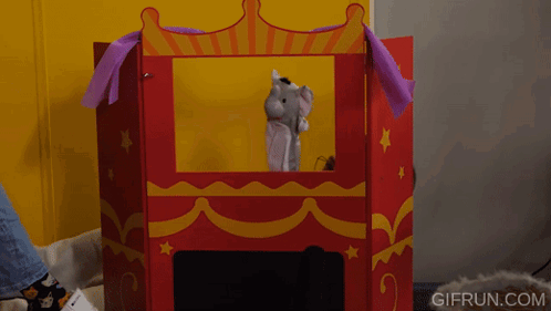 a person playing with a puppet in a puppet theater with gifrun.com written on the bottom right
