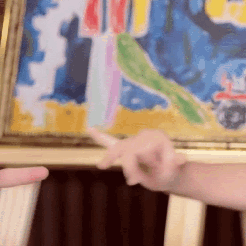 A Person Pointing At A Colorful Painting With A Red Car In The Background GIF