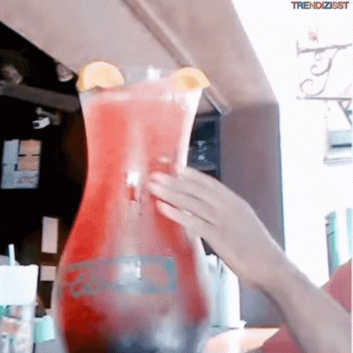 A Person Pouring A Drink Into A Pitcher That Says Trendzisst On The Bottom GIF