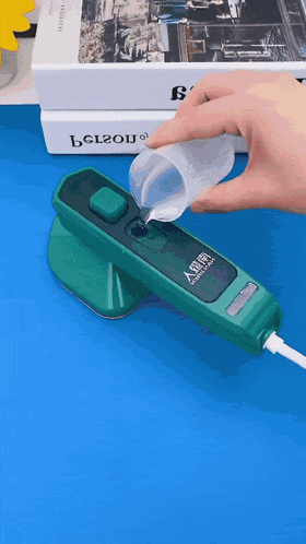 A Person Pouring Liquid Into A Green Device That Says Belzou On The Front GIF