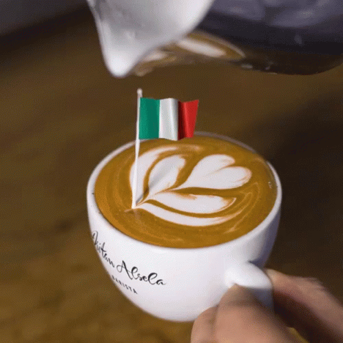 A Person Pouring Milk Into A Cup Of Coffee That Says Aitan Aliola On It GIF