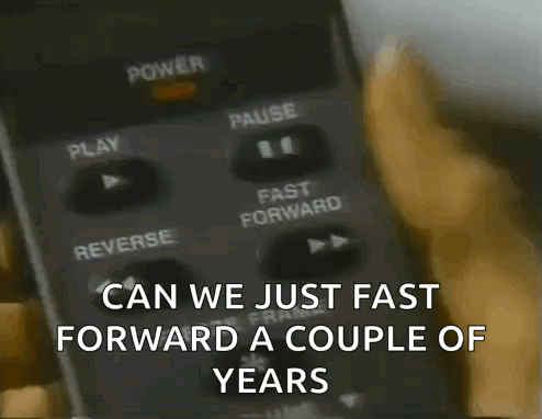A Person Pressing A Button On A Remote Control With The Words Can We Just Fast Forward A Couple Of Years GIF