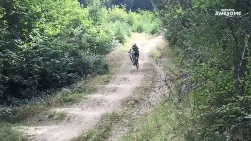 A Person Riding A Bike Down A Dirt Road With The Words Awesome Written On The Bottom GIF