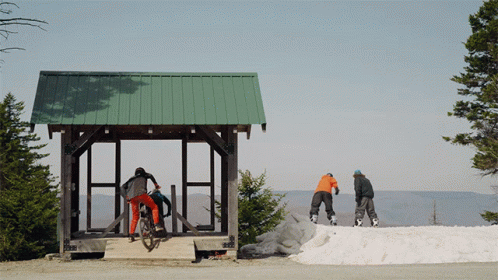 A Person Riding A Bike In Front Of A Green Roof GIF