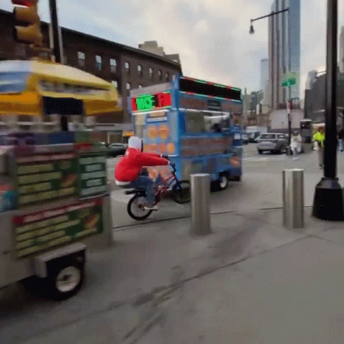 A Person Riding A Bike Next To A Food Truck That Says ' Ice Cream ' On The Side GIF