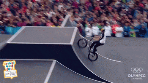 A Person Riding A Bike On A Ramp With The Olympic Channel Written On The Bottom GIF