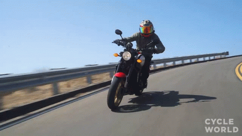 A Person Riding A Motorcycle On A Road With The Words Cycle World Visible GIF