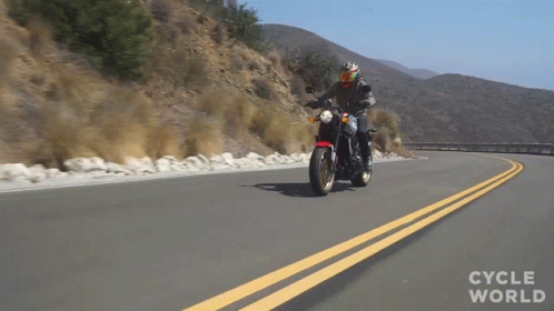 A Person Riding A Motorcycle On A Road With The Words Cycle World Written On The Bottom GIF