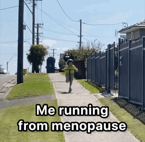 A Person Riding A Scooter Down A Sidewalk With The Words Me Running From Menopause GIF