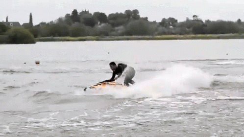 A Person Riding A Surfboard In The Water GIF
