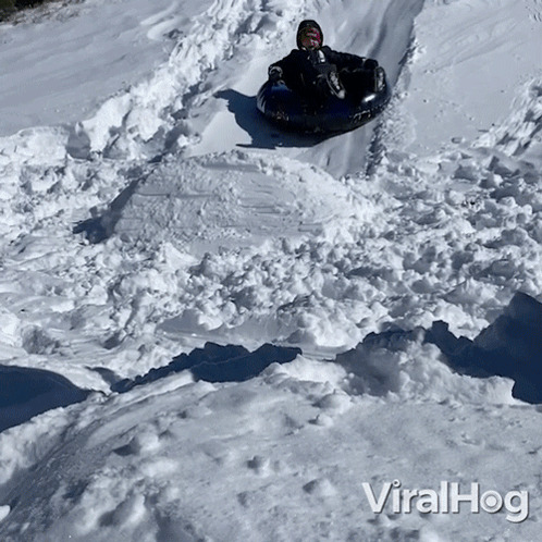 A Person Riding A Tube Down A Snowy Hill With The Words Viralhog On The Bottom Of The Image GIF