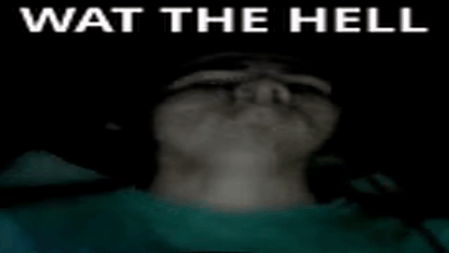 a person 's face is visible in the dark with the words wat the hell written on it .