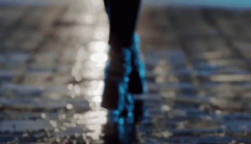 A Person 'S Feet Are Visible In A Blurry Photo As They Walk Through The Water GIF